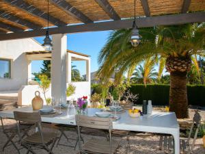 Casas de TorratにあるHoliday Home Casa Romario by Interhomeのヤシの木のあるパティオ(白いテーブルと椅子付)