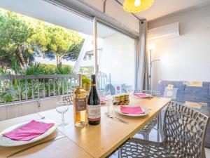 einen Tisch mit einer Flasche Wein und Gläsern in der Unterkunft Apartment Le Grand Pavois-3 by Interhome in Le Grau-du-Roi