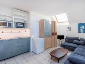 een keuken en een woonkamer met een bank en een tafel bij Apartment Les Marines 1 et 2-7 by Interhome in Cabourg