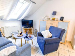 - un salon avec 2 chaises bleues et une télévision dans l'établissement Apartment Juist by Interhome, à Norddeich