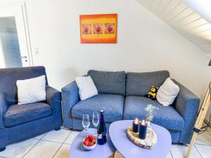 - un salon avec deux canapés bleus et deux tables dans l'établissement Apartment Juist by Interhome, à Norddeich