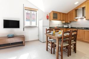 uma cozinha com uma mesa e cadeiras e um frigorífico em Nazaré Boutique Apartment II na Nazaré