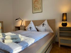 - un lit avec des draps et des oreillers blancs dans l'établissement Apartment App- Paradiso by Interhome, à Paradiso