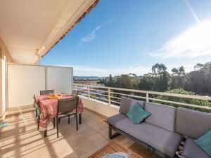 - Balcón con sofá y mesa en Apartment Le Domaine de la Baie-1 by Interhome, en Cavalaire-sur-Mer
