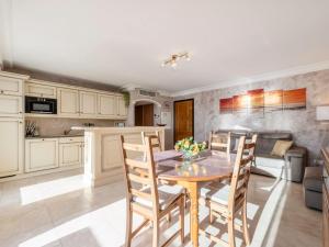 Una cocina con una mesa y sillas de madera en una habitación. en Apartment Le Domaine de la Baie-1 by Interhome, en Cavalaire-sur-Mer