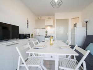 een witte eettafel en stoelen in een keuken bij Studio Voiles d'Or-Gênois-3 by Interhome in Le Grau-du-Roi
