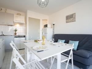 een witte keuken met een witte tafel en stoelen bij Studio Voiles d'Or-Gênois-3 by Interhome in Le Grau-du-Roi