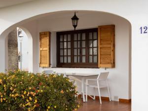 patio con mesa, sillas y ventana en Apartment Son Bou Gardens Apt 2 dorm by Interhome, en Son Bou