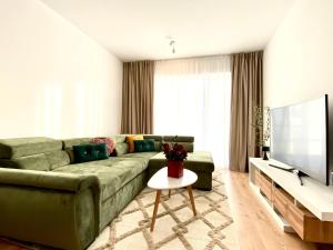 un soggiorno con divano verde e TV di Alphaville 96 a Braşov