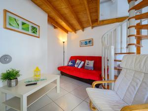 a living room with a red couch and a stairs at Holiday Home Ker Penthièvre by Interhome in Penthièvre