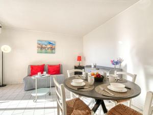ein Wohnzimmer mit einem Tisch, Stühlen und einem Sofa in der Unterkunft Apartment Le Capitole-9 by Interhome in Fréjus