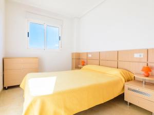 a bedroom with a yellow bed and a window at Apartment Mar by Interhome in El Borseral