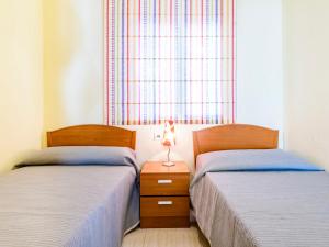 2 camas en un dormitorio con lámpara en una mesita de noche en Apartment Playa Coral I by Interhome, en Oropesa del Mar