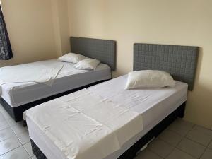 two beds sitting next to each other in a room at Hotel Sirena in Praia Grande