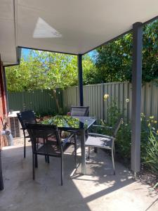a patio with a table and chairs under a canopy at Blue Jay Daylesford in Daylesford