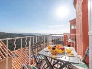 a table with a bowl of fruit on a balcony at Apartment Les Sauvagières II-5 by Interhome in Cavalaire-sur-Mer