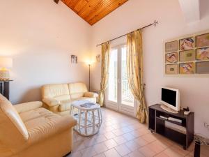 a living room with a couch and a tv at Apartment Les Sauvagières II-5 by Interhome in Cavalaire-sur-Mer