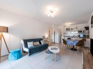 a living room with a blue couch and a table at Apartment Le Domaine-1 by Interhome in Cavalaire-sur-Mer