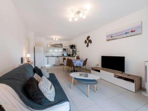 a living room with a couch and a tv at Apartment Le Domaine-1 by Interhome in Cavalaire-sur-Mer