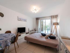 a bedroom with a bed and a desk and a television at Apartment Le Domaine-1 by Interhome in Cavalaire-sur-Mer +18 photos