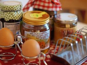 ランピターにあるHoliday Home Cwm Derw by Interhomeの卵と蜂蜜の瓶が入ったテーブル