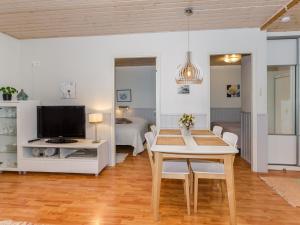 a living room with a table and a tv at Holiday Home Loma-koli 3 by Interhome in Hattusaari