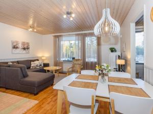 a living room with a table and a couch at Holiday Home Loma-koli 3 by Interhome in Hattusaari