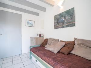 um sofá numa sala de estar com uma pintura de cavalo na parede em Apartment Bastide De L'Olivier by Interhome em Le Grau-du-Roi