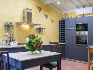 eine Küche mit einem Tisch und einer Blumenvase darauf in der Unterkunft Villa Ghizzano by Interhome in Peccioli