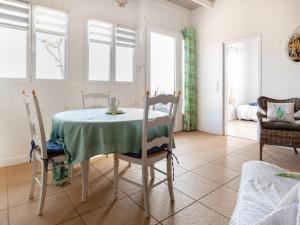 a dining room with a table and chairs and windows at Holiday Home L'Orme by Interhome in Loupiac