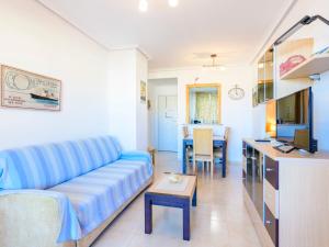 sala de estar con sofá azul y cocina en Apartment Altamar by Interhome, en Oropesa del Mar
