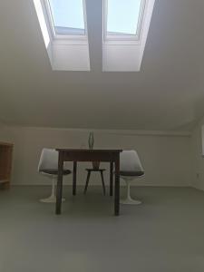 uma mesa e duas cadeiras num quarto com janelas em Bretzenstudios em Hall in Tirol