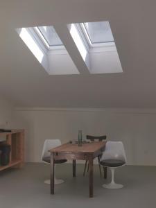 a room with a table and chairs and a skylight at Bretzenstudios in Hall in Tirol