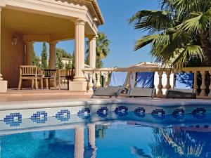basen z krzesłami obok domu w obiekcie Villa Calpetenis by Interhome w mieście Calpe