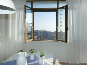 una finestra con due piante in vaso su un tavolo di Apartment International by Interhome a Pompeiana