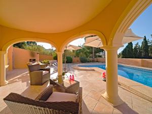 patio z krzesłami i basenem w obiekcie Villa Gardenia by Interhome w mieście Calpe