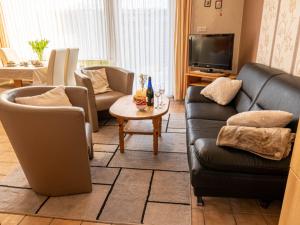 a living room with couches and a tv at Holiday Home Siggi by Interhome in Norddeich