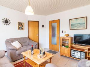 sala de estar con sofá y TV en Holiday Home Helga by Interhome, en Norddeich