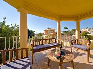 a porch with two chairs and a table with a bottle of wine at Villa Villa Acuario by Interhome in Calpe +31 photos