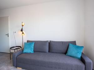 a couch with two blue pillows in a living room at Apartment Indigo Bay by Interhome in Le Lavandou