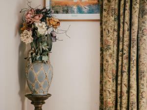 a vase with flowers on a stand next to a wall at Holiday Home Ceilidhtail Cottage by Interhome in Drumnadrochit