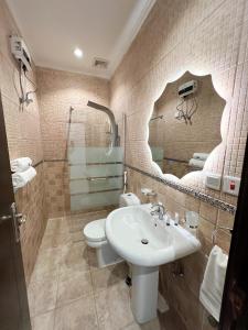 a bathroom with a sink and a toilet and a mirror at Almasarat Tower Sea View in Jeddah +99 photos