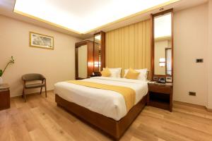 a hotel room with a large bed and a mirror at Marine Inn Hotel in Cochin