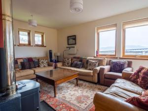 a living room with couches and a coffee table at Holiday Home Peter's Shed by Interhome in Drumnadrochit