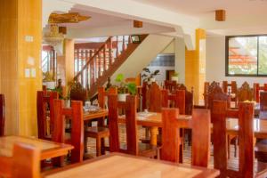a dining room with wooden tables and chairs at D'MESA Seacretlodge and Restaurant in Taytay
