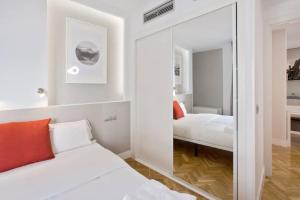 a bedroom with a mirror next to a bed at Apar. renovado en Leganitos (Gran Vía) con portero in Madrid