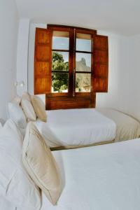 two beds in a room with a window at Texeda Room Suites in Tejeda