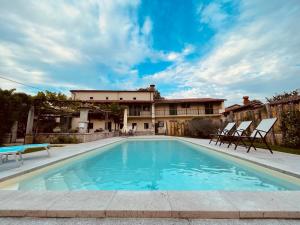 une piscine avec des chaises et une maison en arrière-plan dans l'établissement Casa Bandel, à Komen