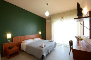 a bedroom with a bed and a green wall at Hotel Royal in Giulianova
