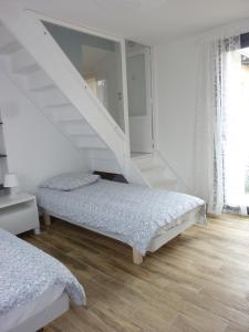 1 dormitorio con 2 camas y escalera en Le Petite des Bouchots, en Les Boucholeurs